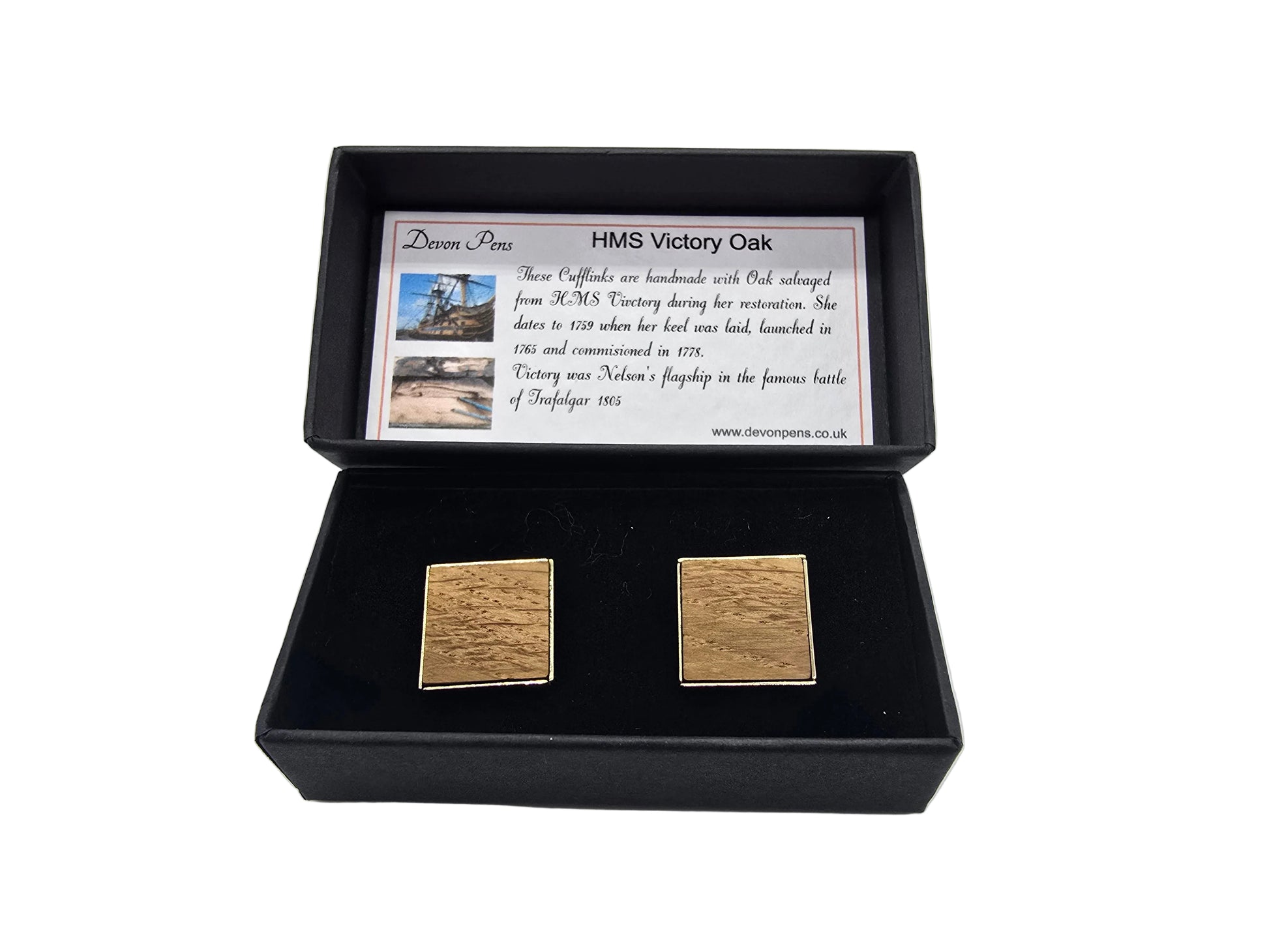 Gold square cufflinks in a black box with a card on a white background
